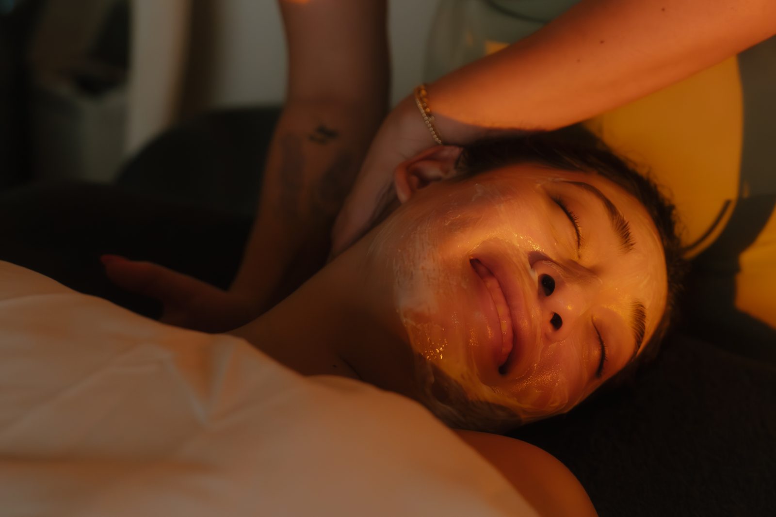 Client with a glowing complexion after a facial treatment at Aura Aesthetics
